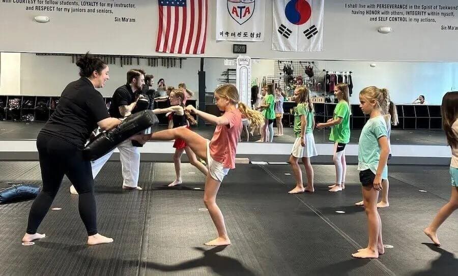 girls practicing kicks during a taekwondo lesson