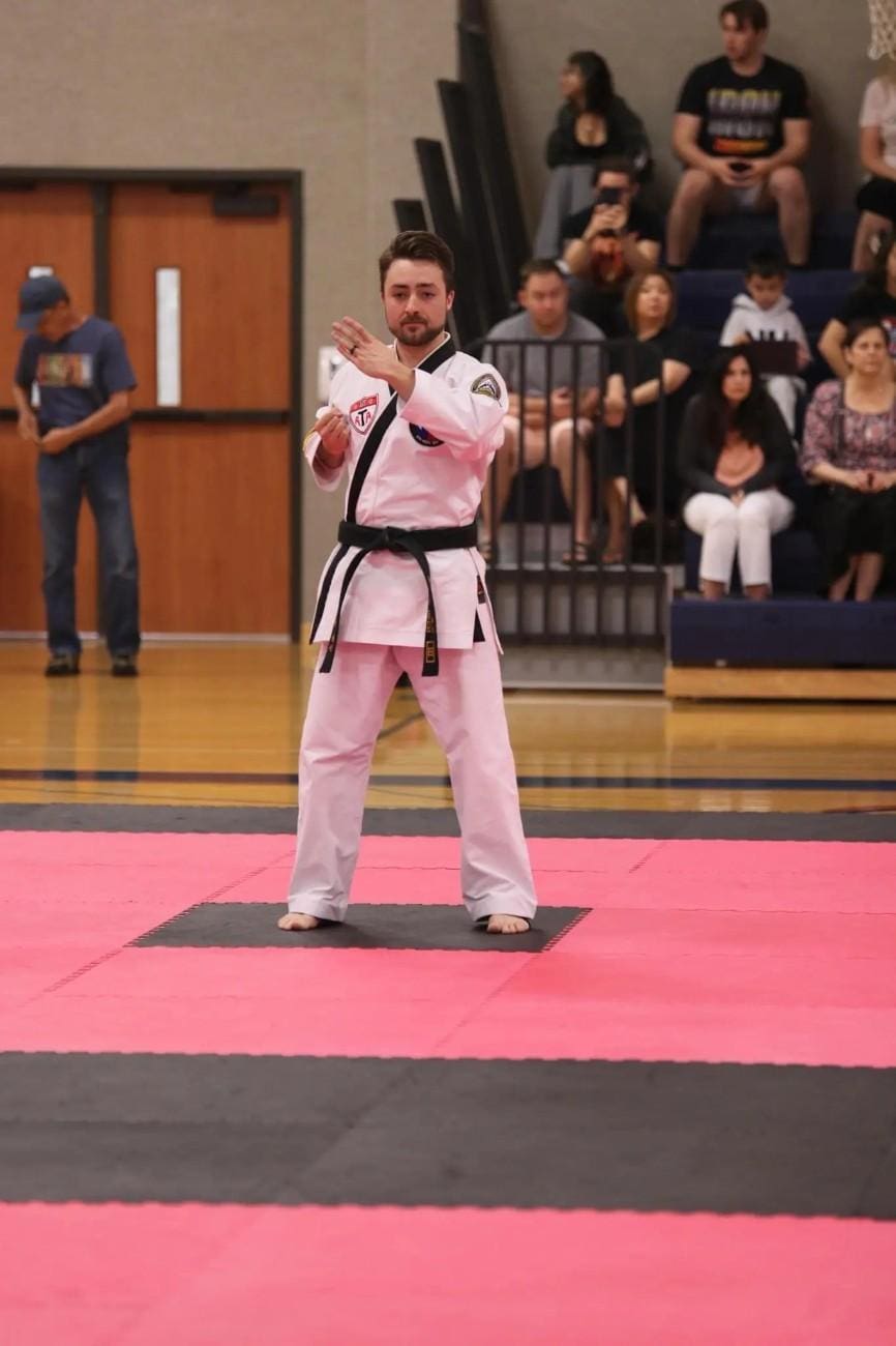 Taekwondo student performing a form during a martial arts competition