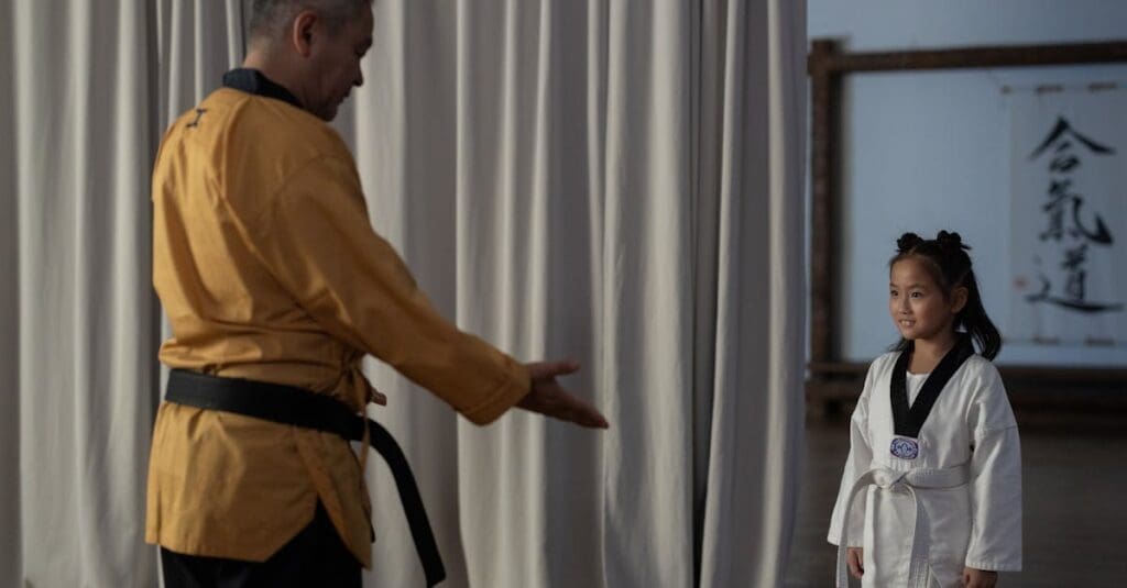 Instructor greeting young student before confidence building martial arts practice