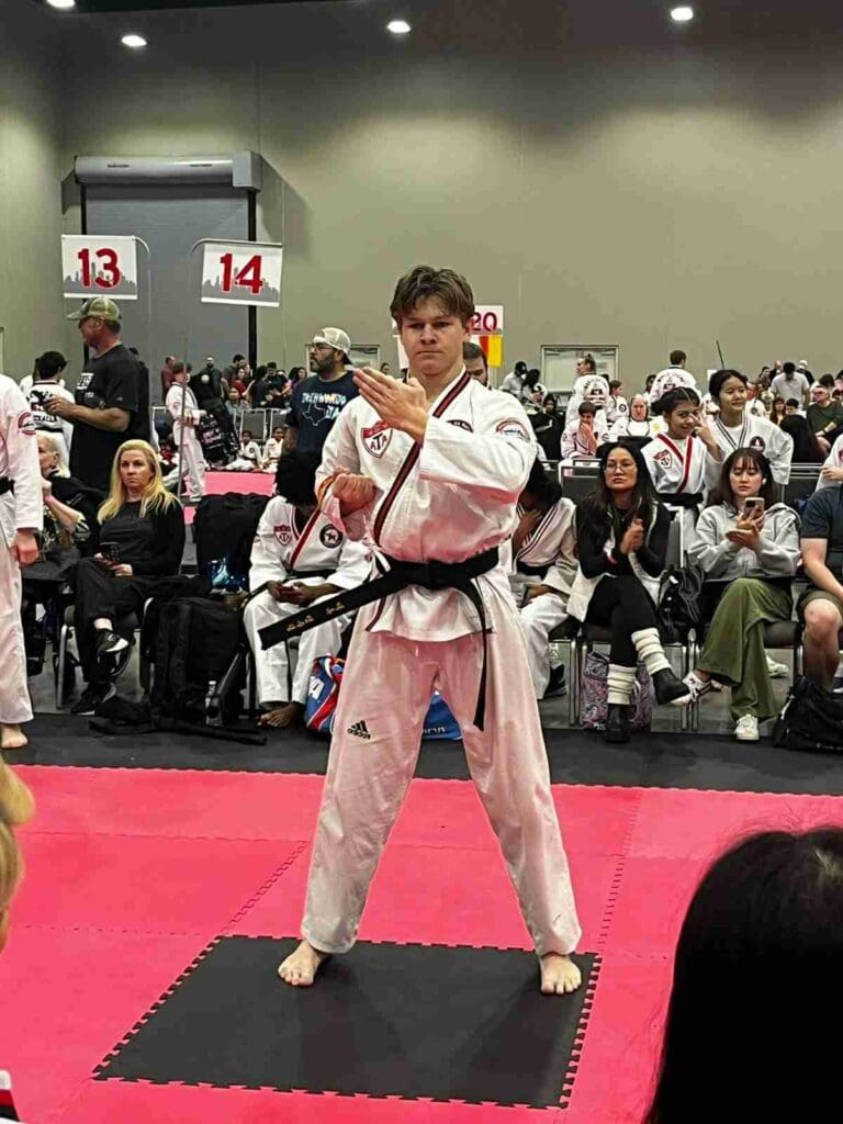 Adult martial artist performing a traditional hand technique during a tournament competition, following an adult martial arts training guide.