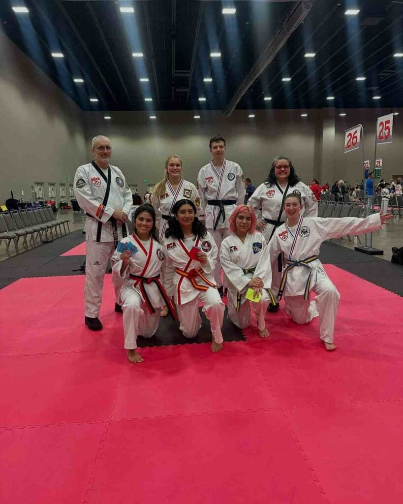 Adult martial arts students posing together after a tournament event, highlighting community and progress in an adult martial arts training guide.