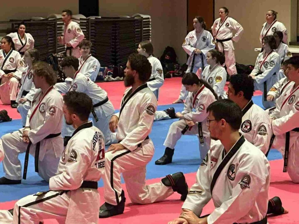 Adult martial artists kneeling during a structured training session at a martial arts event, learning discipline through an adult martial arts training guide.